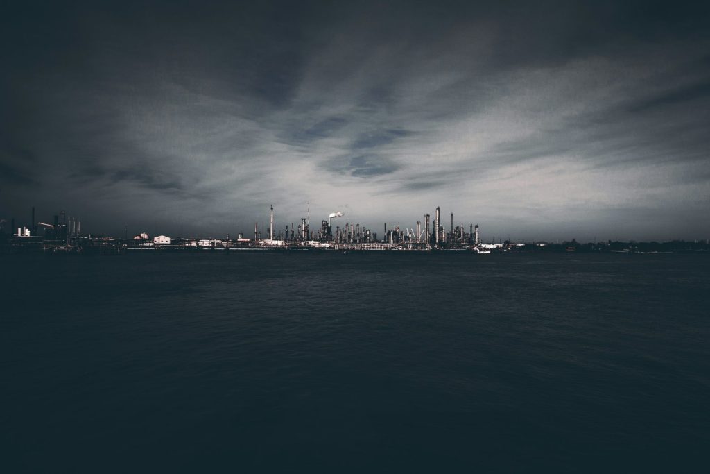 Industrial cityscape viewed from across dark water.